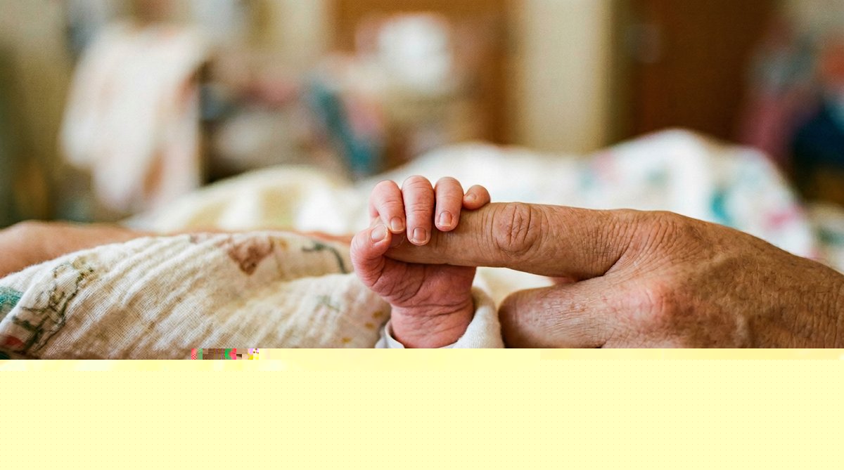 Lily's tiny hand holding her parent's finger in the NICU
